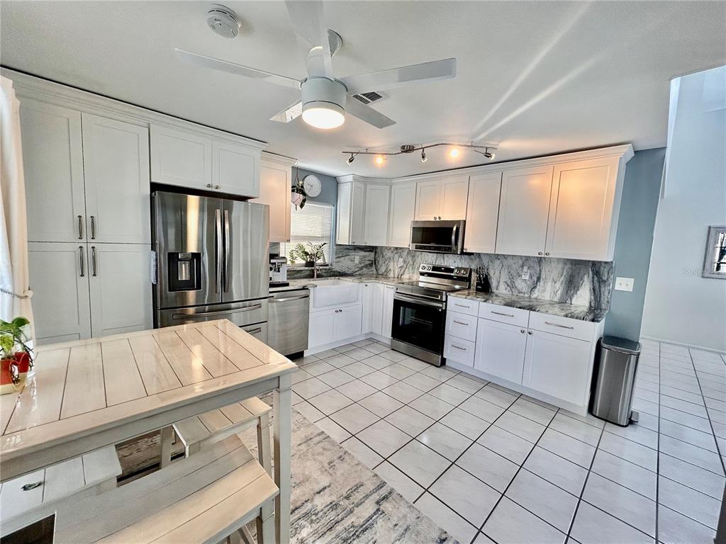 8911 Welsh Way Hudson, FL 34667 - Photo 10 of 33 a kitchen with stainless steel appliances granite countertop a stove sink and cabinets
