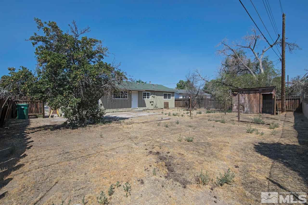 1230 Butler Street Reno, NV 89512 - Photo 19 of 21 a backyard of a house with table and chairs under an umbrella