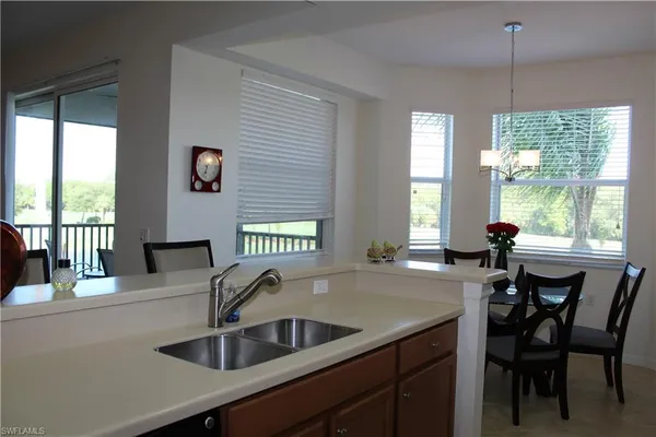 a kitchen with a sink a counter and chairs