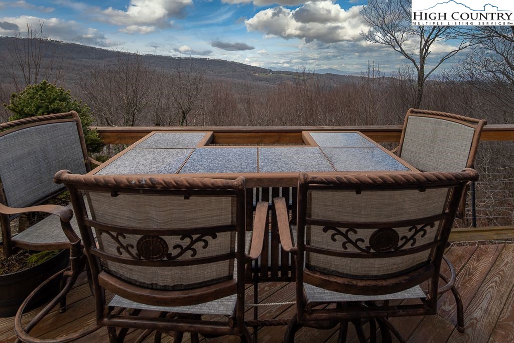 201 Pinnacle Ridge Road Beech Mountain, NC 28604 - Photo 8 of 26 a view of a patio with table and chairs with wooden floor and plants