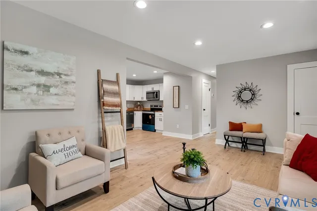 a living room with furniture and a view of kitchen