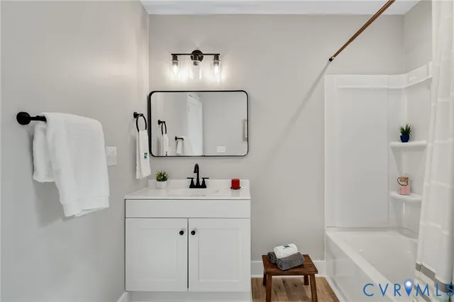 a bathroom with a tub sink a mirror and a shower