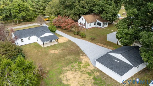 an aerial view of a house with pool garden and trees