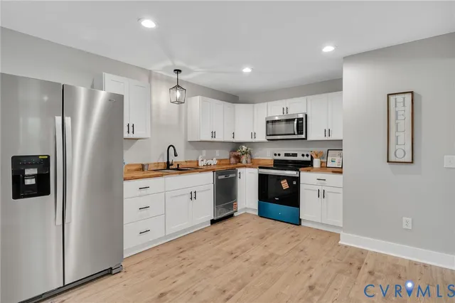 a kitchen with granite countertop a refrigerator stove top oven and sink