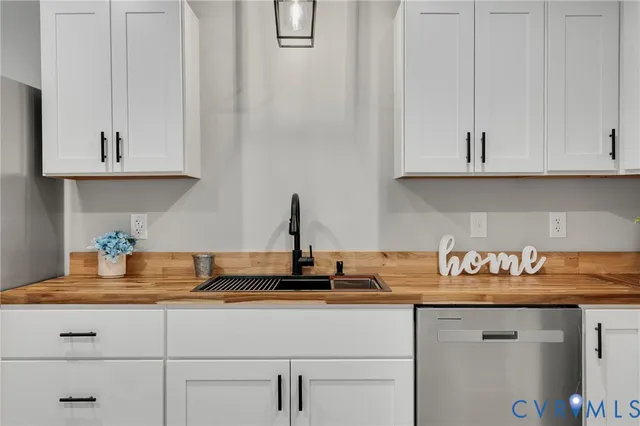 a kitchen with granite countertop white cabinets and a sink