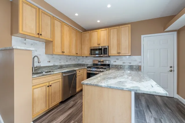 a kitchen with stainless steel appliances granite countertop a stove a sink and a microwave