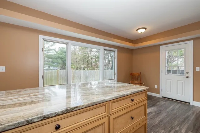 a bathroom with a granite countertop sink a toilet and a mirror