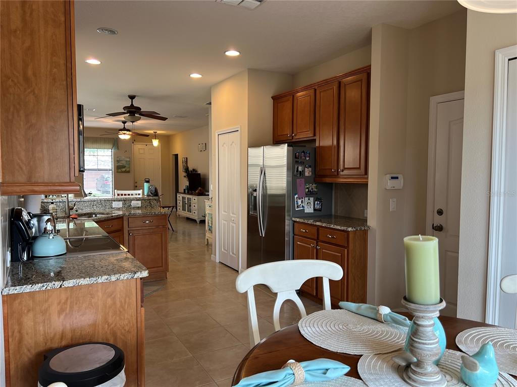 2002 Fishtail Fern Way Ocoee, FL 34761 - Photo 15 of 51 a kitchen with sink refrigerator dining table and chairs