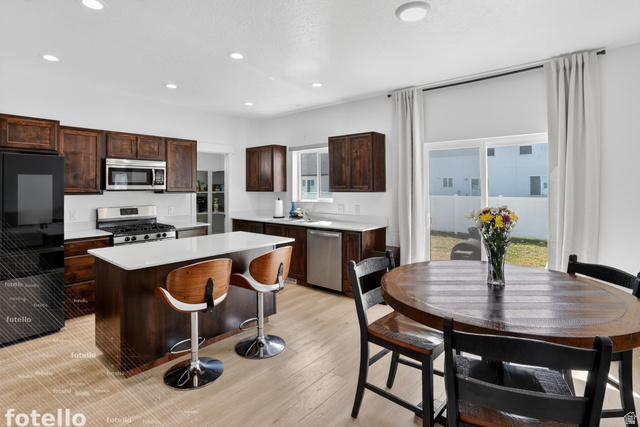 815 West Powderwood Lane Mapleton, UT 84664 - Photo 11 of 39 Kitchen with stainless steel appliances, light countertops, a center island, dark wood finish cabinetry, and a breakfast bar