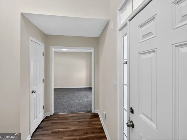 a view of a hallway with wooden floor and staircase