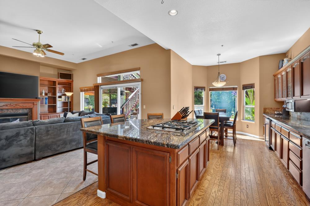 6504 Swallowsview Court Rocklin, CA 95677 - Photo 15 of 66 a kitchen with stainless steel appliances a stove a sink dishwasher and a dining table with wooden floor