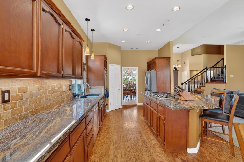 6504 Swallowsview Court Rocklin, CA 95677 - Photo 18 of 66 a kitchen with stainless steel appliances granite countertop counter top space a sink a refrigerator and wooden floor
