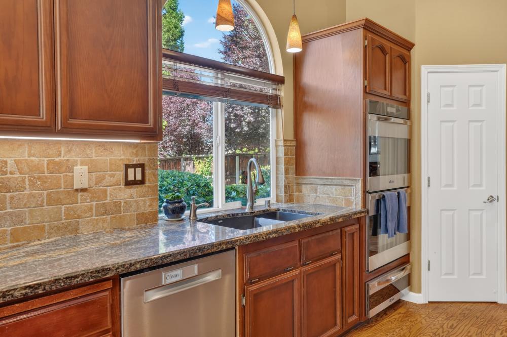 6504 Swallowsview Court Rocklin, CA 95677 - Photo 20 of 66 a kitchen with granite countertop stainless steel appliances a sink and cabinets