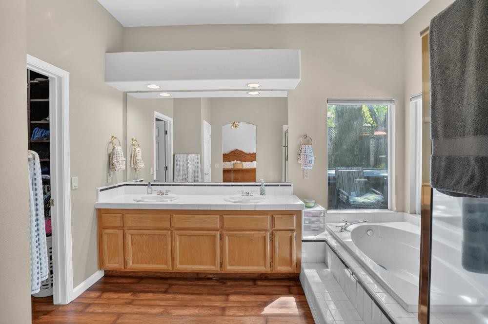 6504 Swallowsview Court Rocklin, CA 95677 - Photo 33 of 66 a bathroom with a tub a double vanity sink and mirror