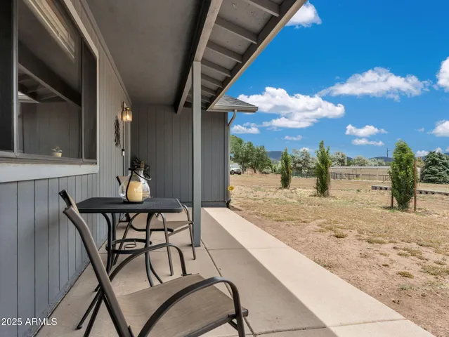 a view of a porch with furniture and a yard