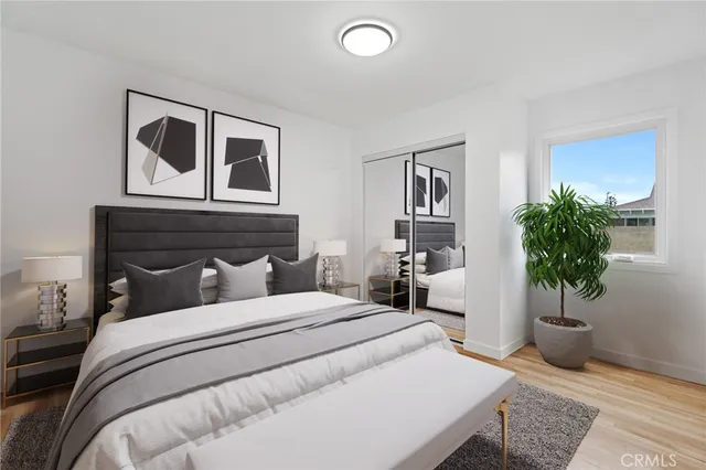 a bedroom with a large bed and a potted plant