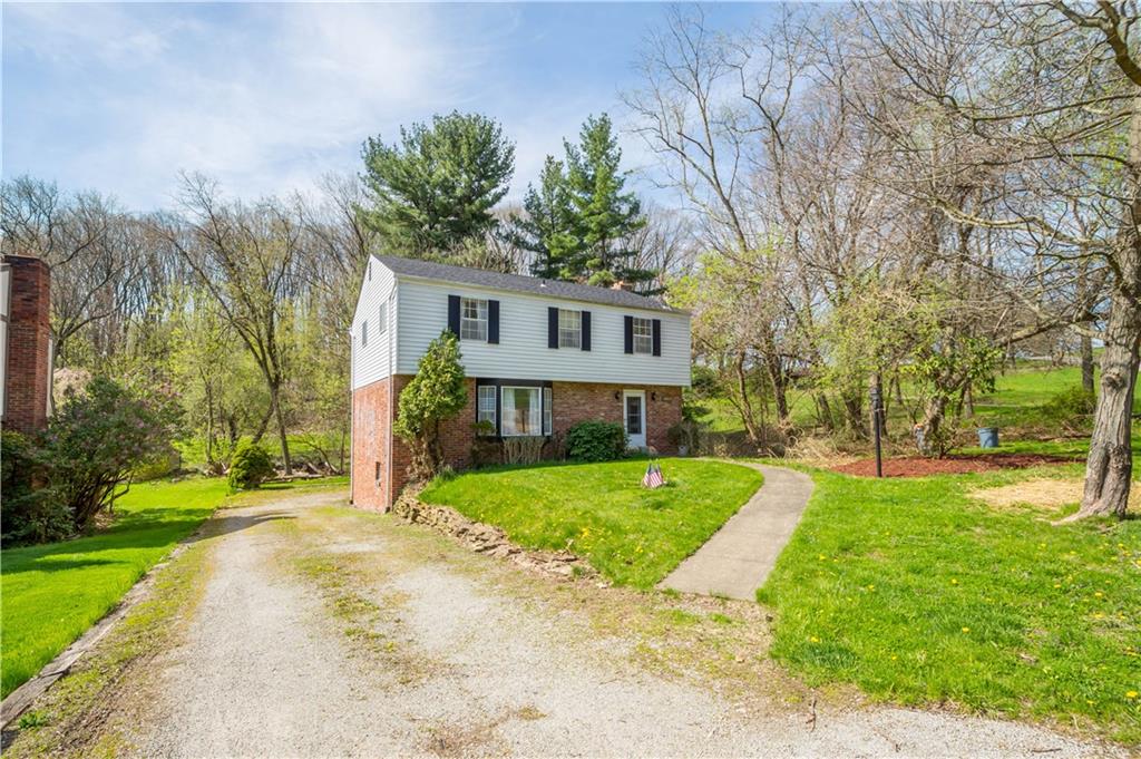 a front view of a house with a yard and trees