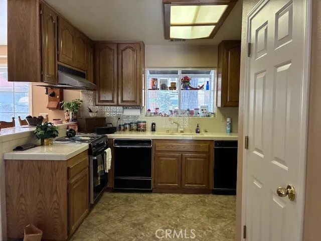a kitchen with stainless steel appliances granite countertop a sink stove and cabinets