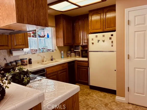 a kitchen with stainless steel appliances a refrigerator a sink a stove and white cabinets