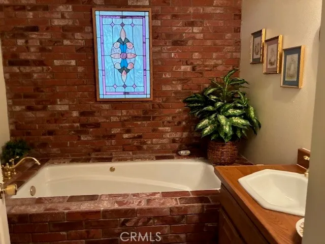 a bathroom with a granite countertop sink and a bathtub