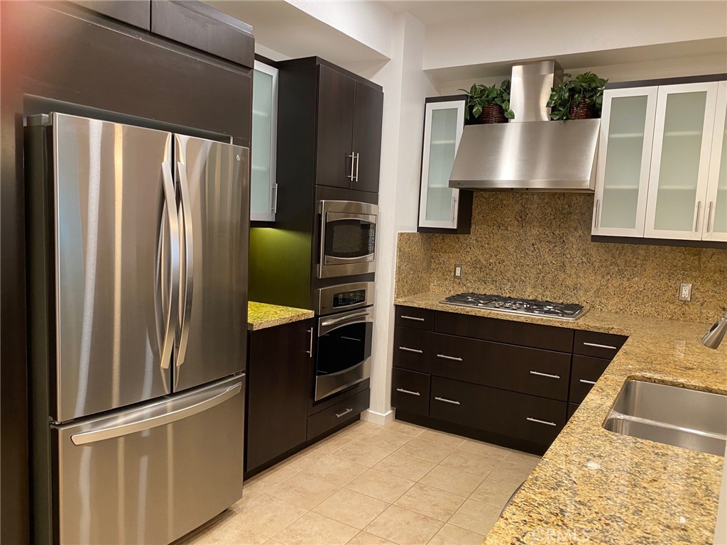 21 Gramercy, Unit 112 Irvine, CA 92612 - Photo 4 of 16 a kitchen with stainless steel appliances granite countertop a refrigerator and a stove