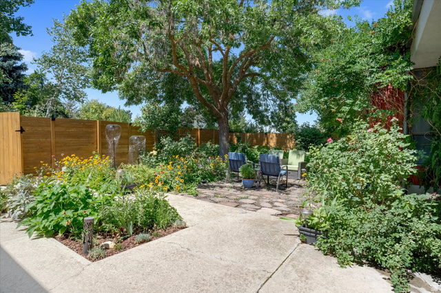 510 Spring Creek Road Providence, UT 84332 - Photo 66 of 97 Landscaped backyard featuring a mature tree, stone patio, and perimeter fencing