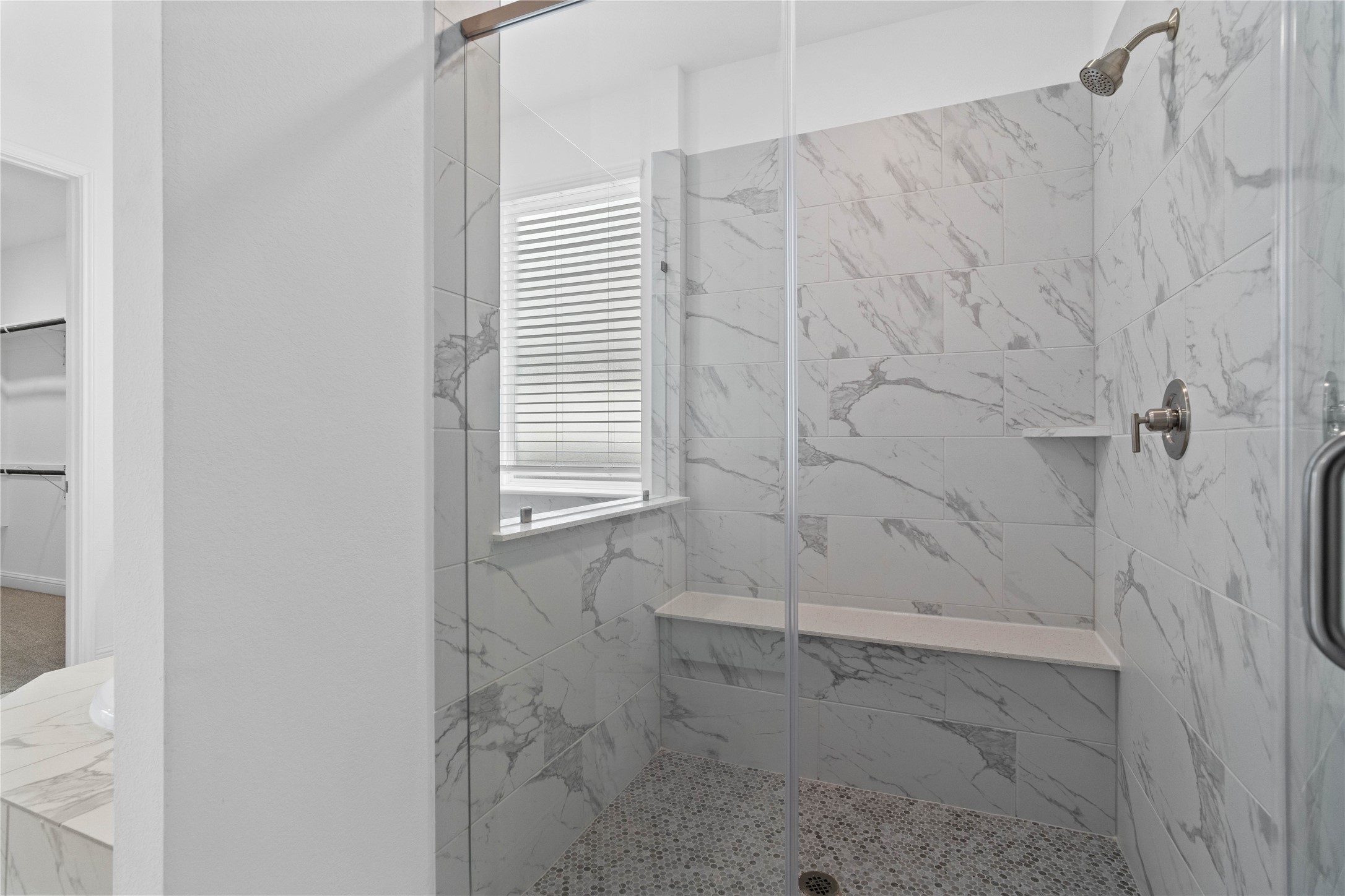 17315 July Moon Lane Conroe, TX 77302 - Photo 28 of 46 The walk-in shower includes a convenient, integrated bench with a niche shelf, offering comfort, extra storage space, and a high-end, custom appearance.