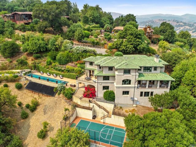 an aerial view of residential houses with outdoor space and trees all around