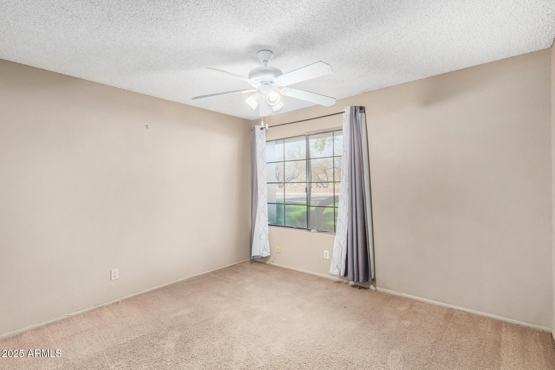 609 East Mesquite Circle, Unit D131 Tempe, AZ 85288 - Photo 16 of 39 an empty room with chandelier fan and windows