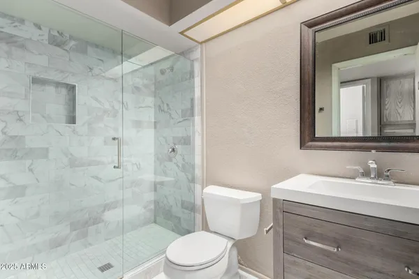 a bathroom with a sink a toilet and shower