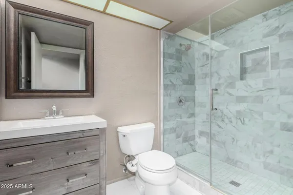 a bathroom with a toilet a sink a vanity and mirror