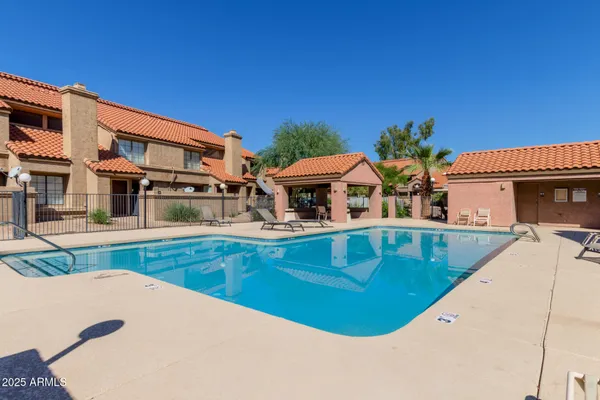 a view of a house with pool and chairs