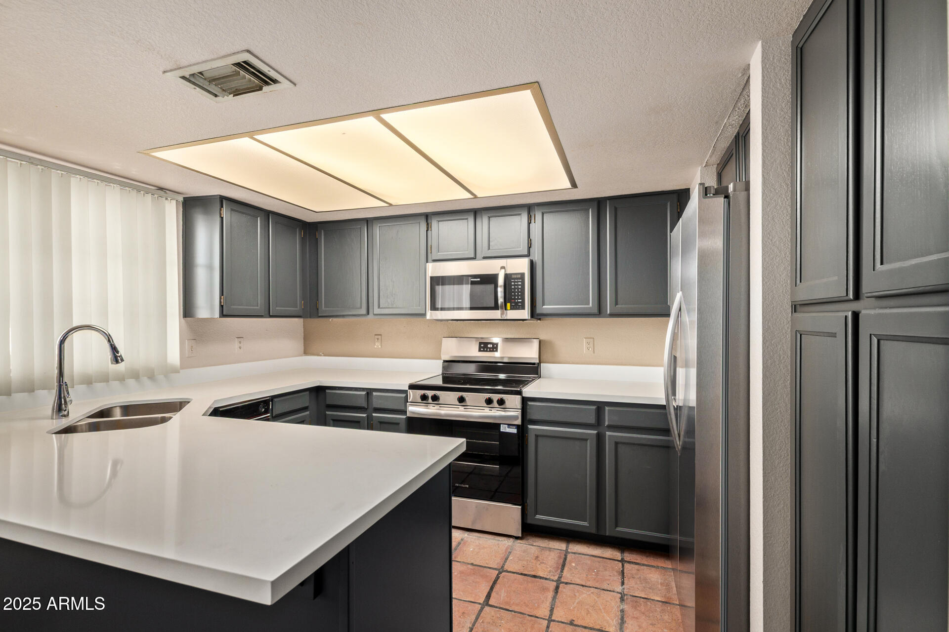 609 East Mesquite Circle, Unit D131 Tempe, AZ 85288 - Photo 10 of 39 a kitchen with a sink a stove and refrigerator