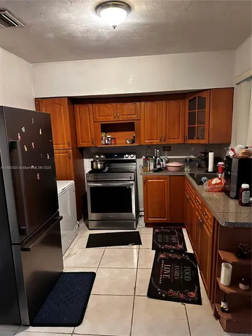 a kitchen with stainless steel appliances a stove a sink and a refrigerator