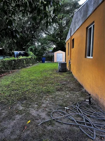 a backyard of a house with plants and tree