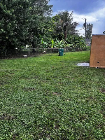 a view of a field of grass and trees