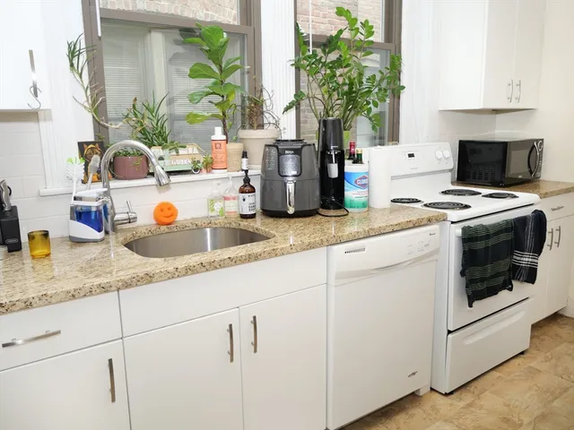 a kitchen with granite countertop a white stove and cabinets