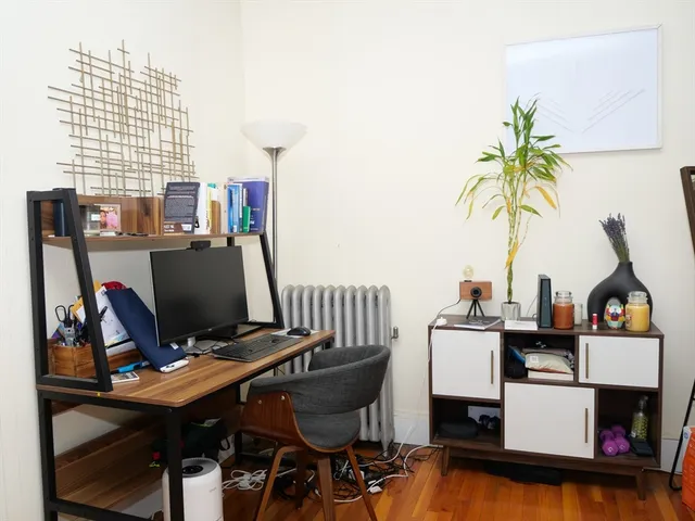 a view of a workspace with furniture and a window