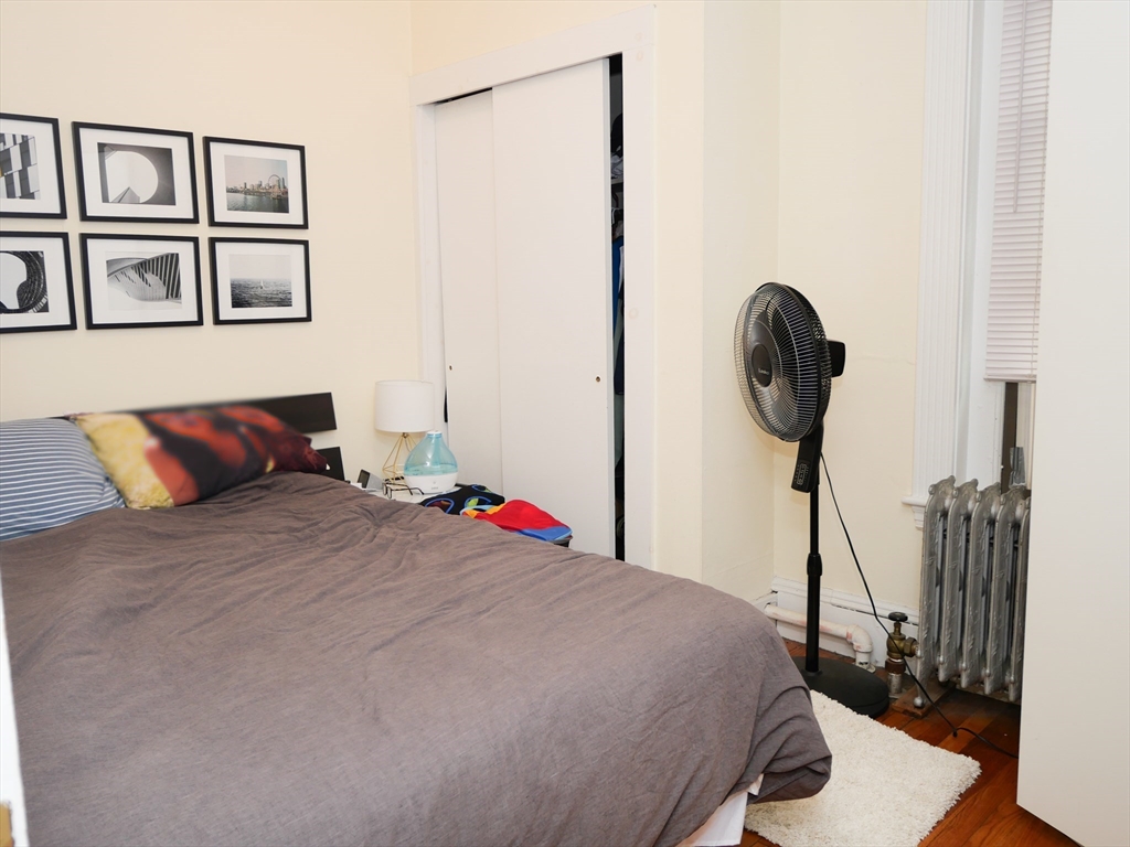 1390 Beacon Street, Unit 12 Brookline, MA 02446 - Photo 7 of 9 a bedroom with a bed and a painting on the wall