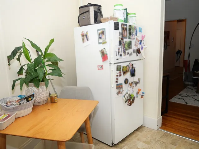 a white kitchen with a refrigerator and a stove