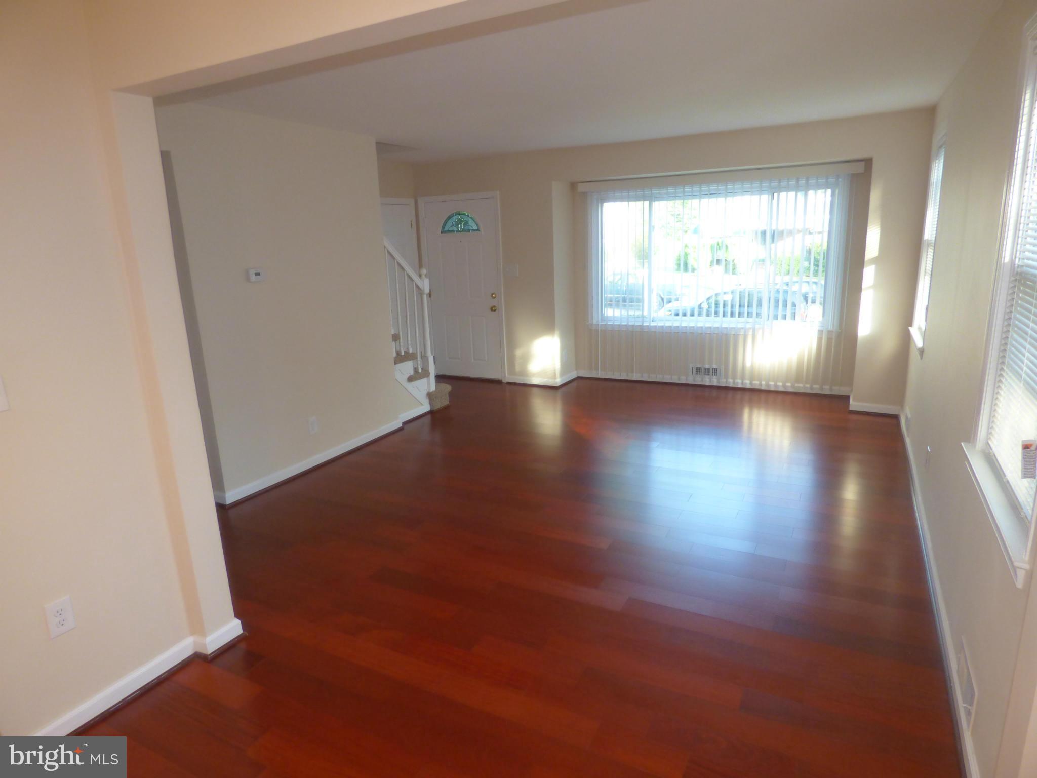 3405 Mayfair Road Baltimore, MD 21207 - Photo 2 of 27 an empty room with wooden floor and windows