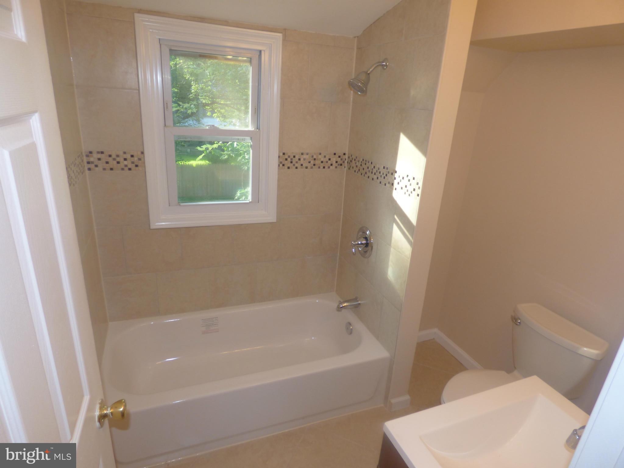 3405 Mayfair Road Baltimore, MD 21207 - Photo 12 of 27 a white bath tub sitting next to a toilet