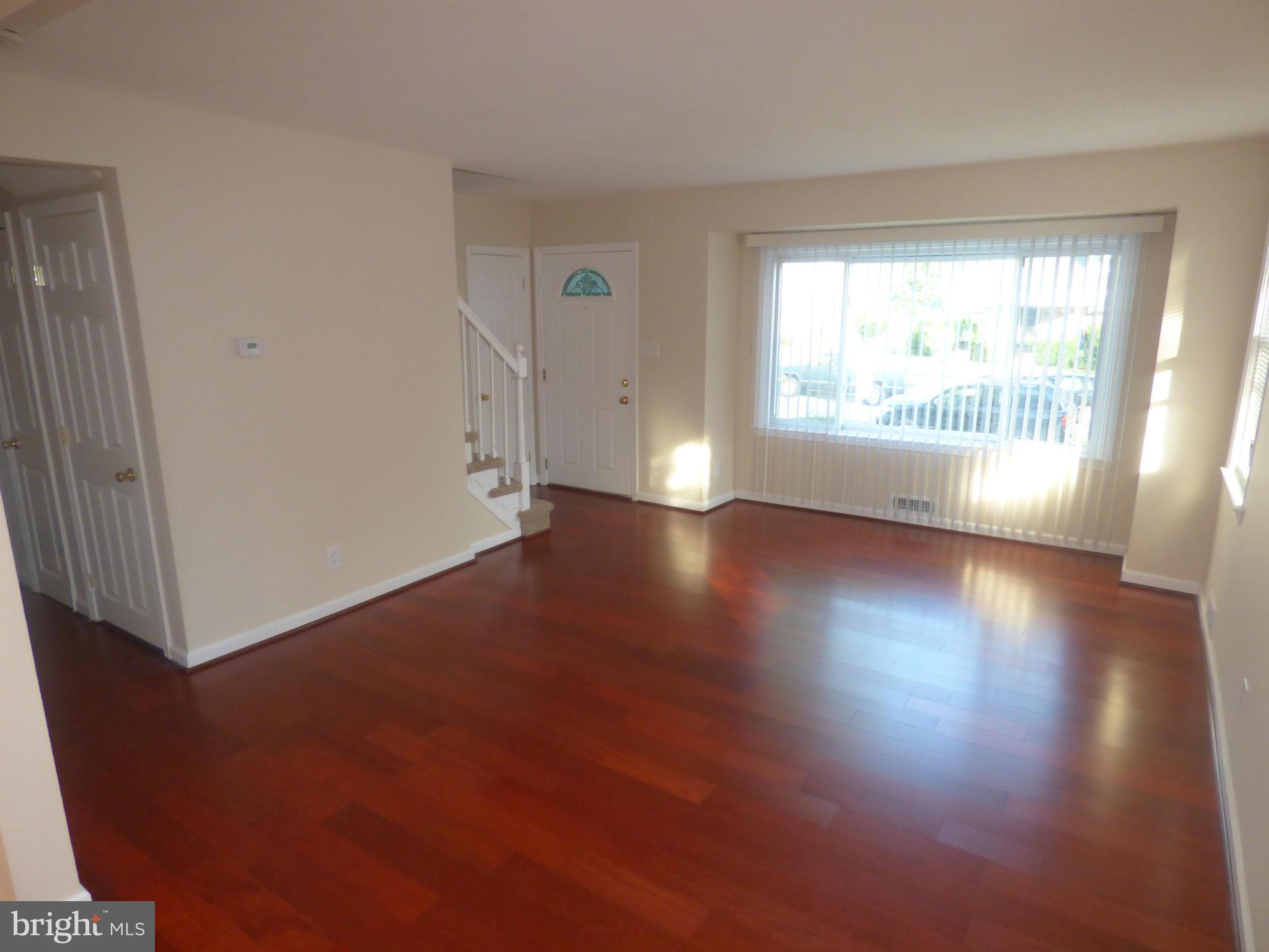 3405 Mayfair Road Baltimore, MD 21207 - Photo 5 of 27 an empty room with wooden floor and windows