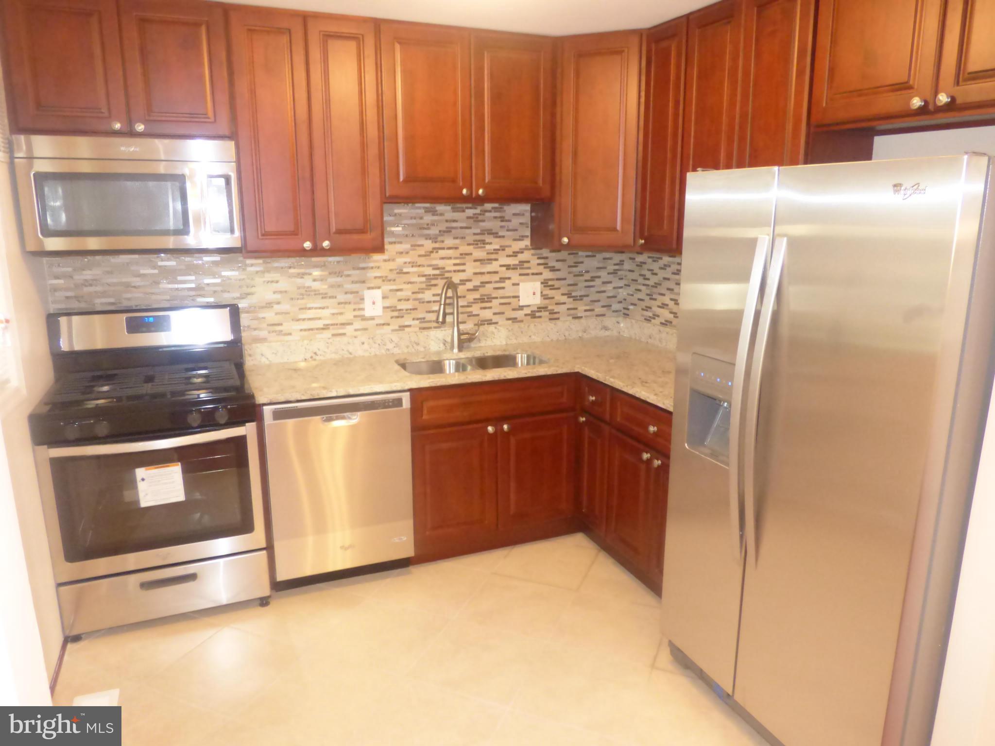 3405 Mayfair Road Baltimore, MD 21207 - Photo 7 of 27 a kitchen with stainless steel appliances granite countertop a refrigerator and a sink