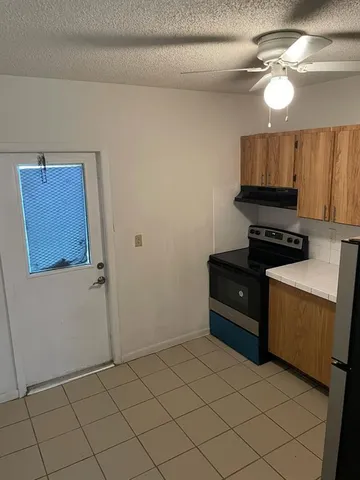 a kitchen with a refrigerator and a stove top oven