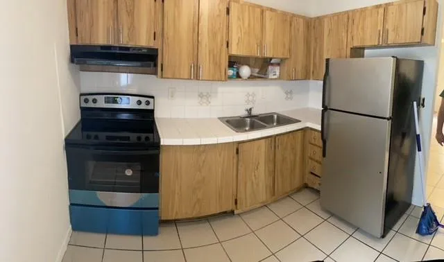 a kitchen with a refrigerator sink and cabinets