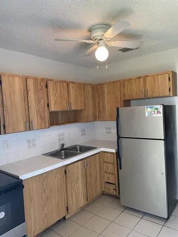 a kitchen with stainless steel appliances granite countertop a refrigerator a sink a stove a microwave and island