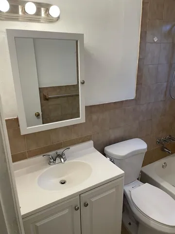 a bathroom with a toilet sink and mirror