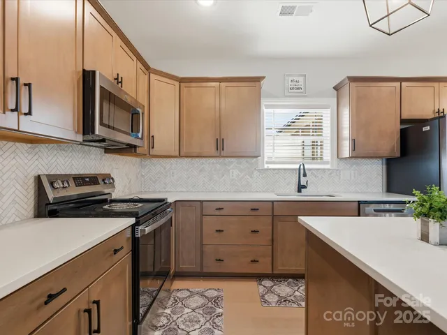 a kitchen with stainless steel appliances granite countertop a sink stove and microwave