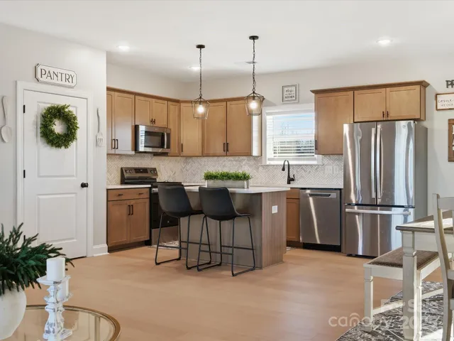 a kitchen with kitchen island a counter space a sink appliances and cabinets